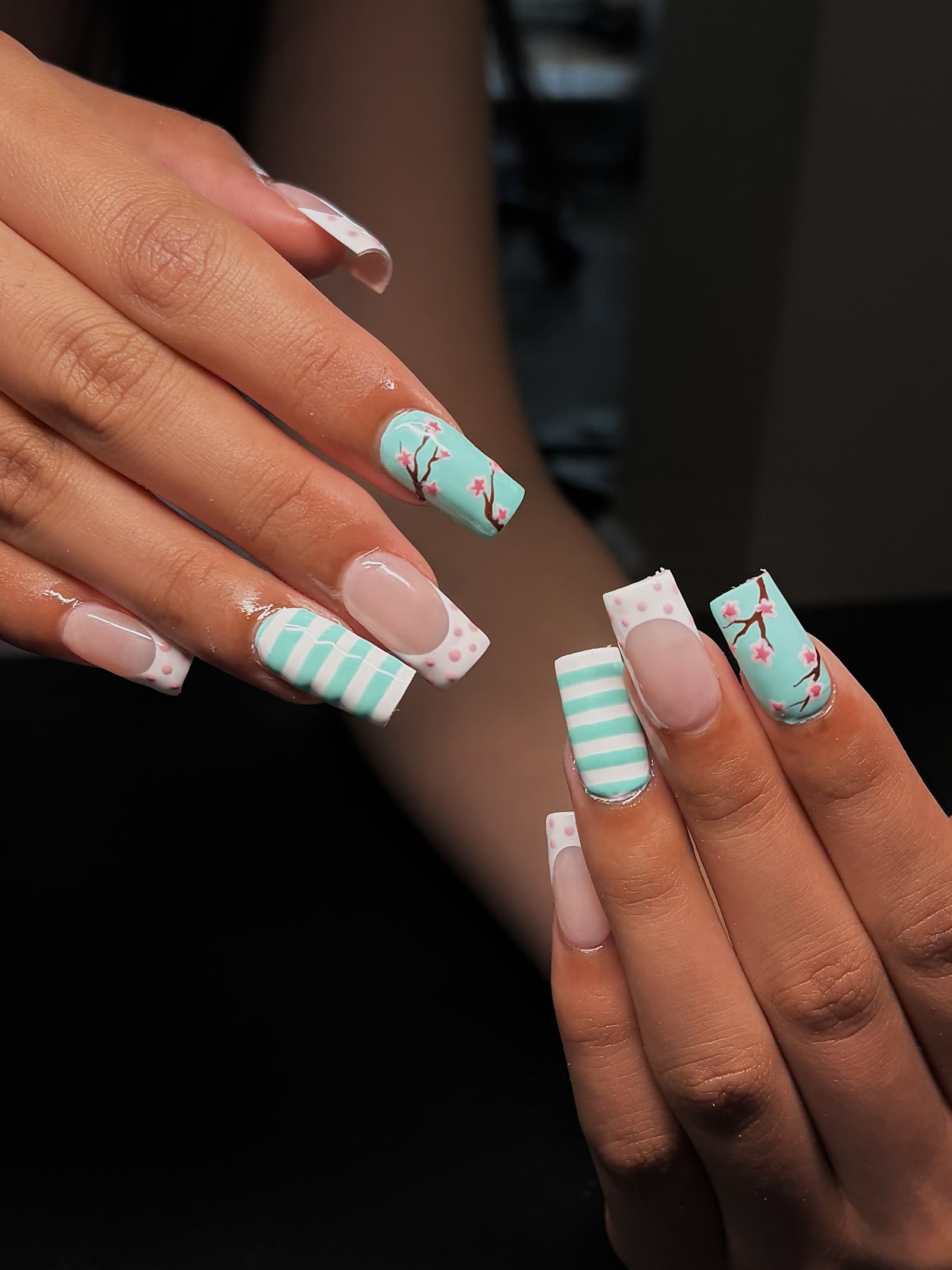 Long square nails in mint and white with cherry-blossom branches, bands and pink polka dots