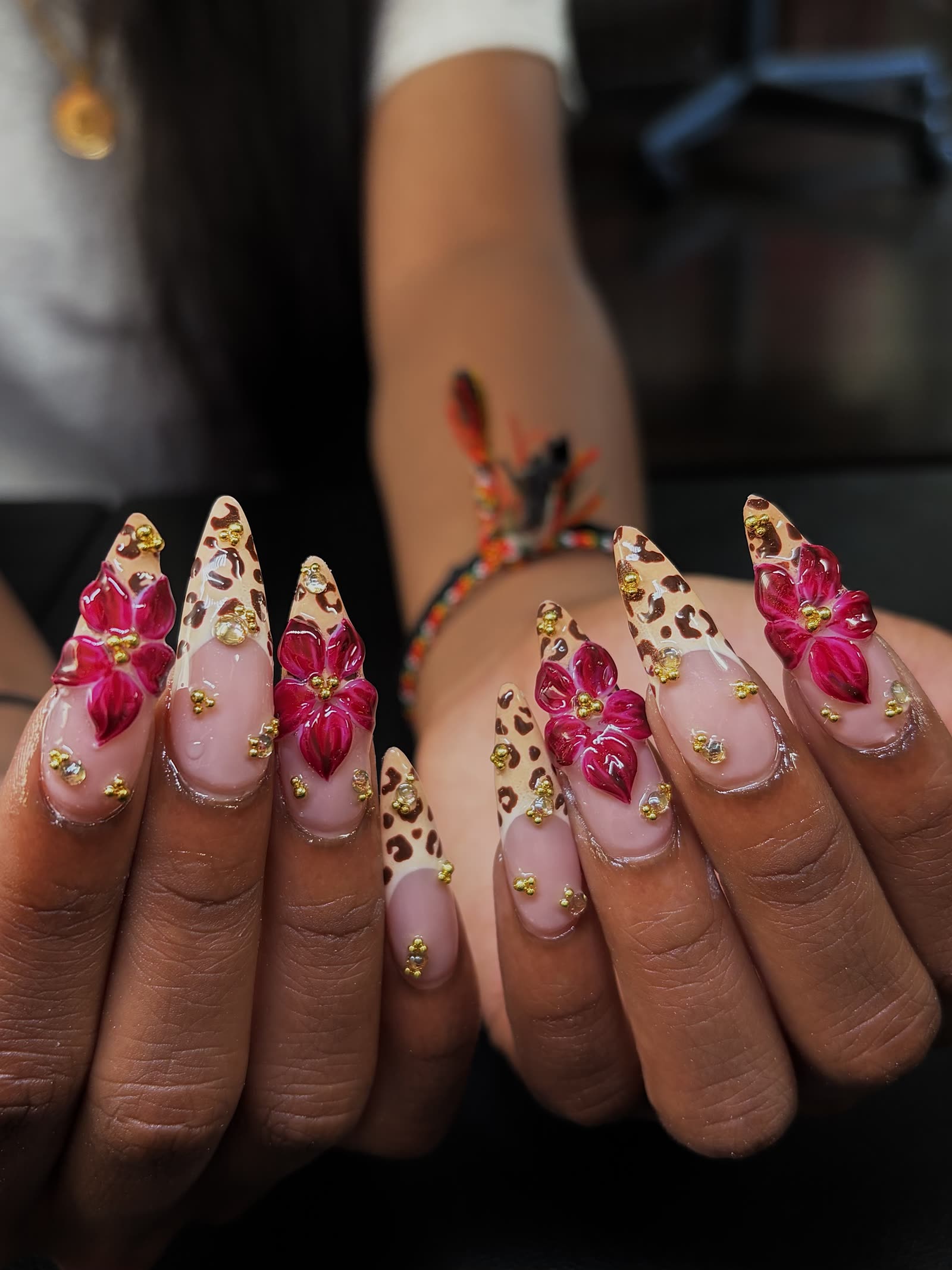 Long stiletto nails in tan leopard print with gold caviar beads and large 3D magenta orchids