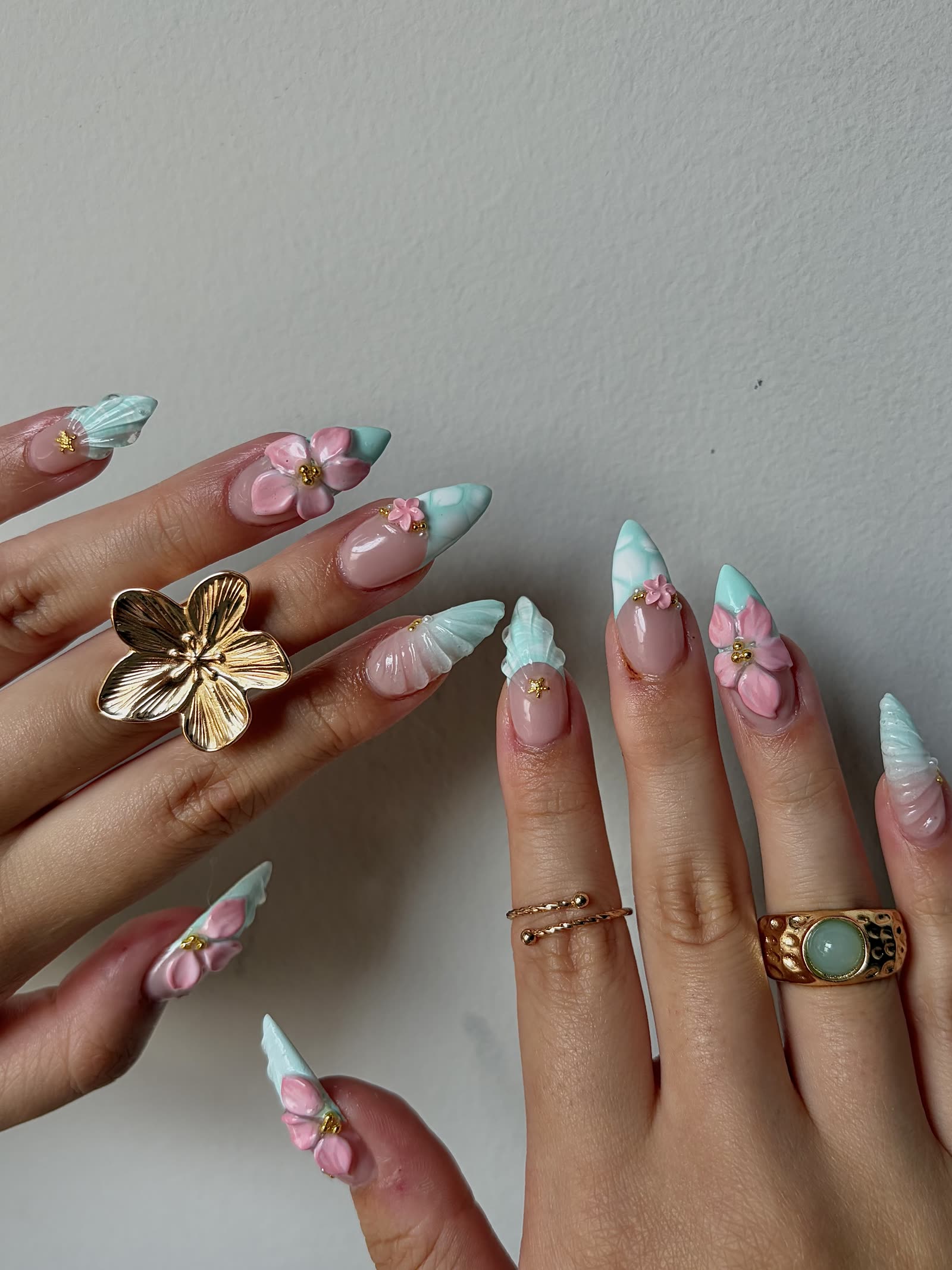 Pale mint and pink almond nails with 3D sculpted blossoms and shell-textured tips